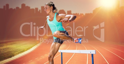 Athlete running over hurdle