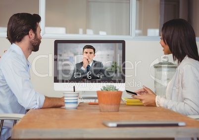 Business executives having video call with colleague on desktop computer