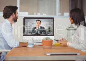 Business executives having video call with colleague on desktop computer