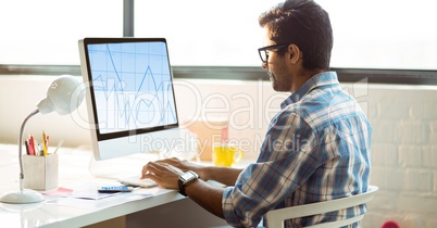 Graphic designer working on computer at desk