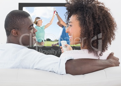 Couple smiling while watching golf on television