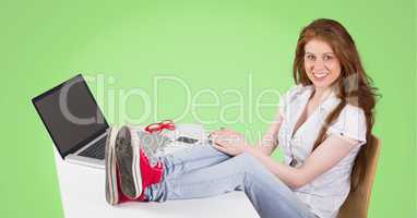 Woman sitting on her desk against green background