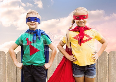 Two children wearing superhero costume standing with hands on hip