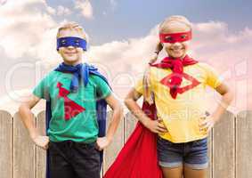 Two children wearing superhero costume standing with hands on hip