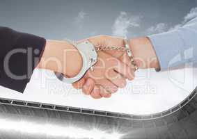 Digital composite image of business professional shaking hands with hand cuffs