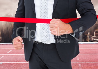Businessman crossing the finish line in ground
