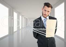 Businessman tied up in rope in corridor