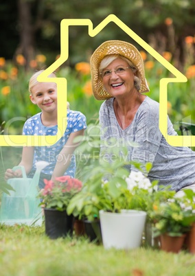 Grandmother and granddaughter watering plants in garden against house outline in background