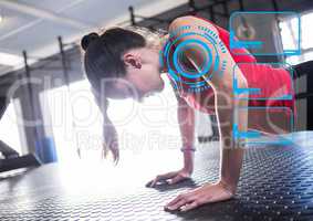 Woman doing push ups and digital interface in gym