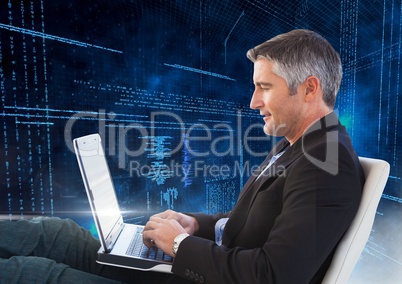 Man sitting on chair using laptop with binary codes in background