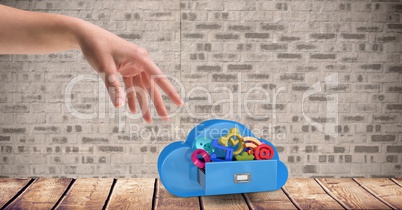 Female hand with cloud shape and icons against brick wall