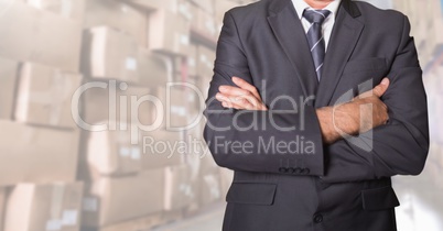 Businessman standing with his arms crossed at warehouse