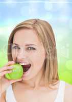 Woman eating an apple against blue green background
