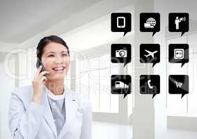 Businesswoman talking on mobile phone next to application icons