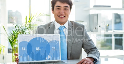 Portrait of businessman using laptop in office