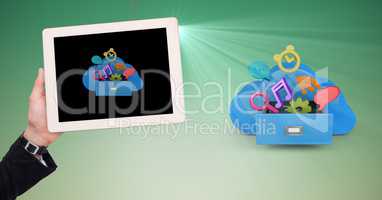 Hand holding digital tablet against application icons on green background