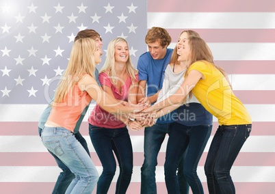 Friends with their hands stacked against american flag in background