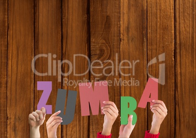 Hands holding word Zumba against wooden background
