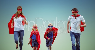 Family in superhero costume running together against sky blue background
