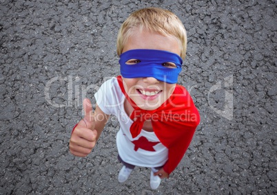 Boy in superhero costume showing thumbs up