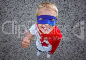 Boy in superhero costume showing thumbs up