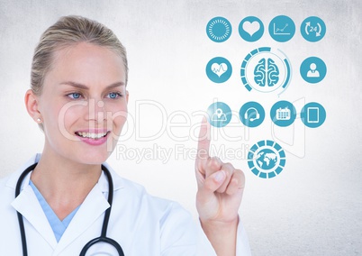 Doctor touching digitally generated medical icons against white background