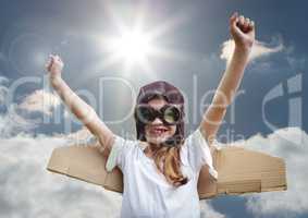 Portrait of excited smiling kid pretending to be a pilot against bright sunlight background