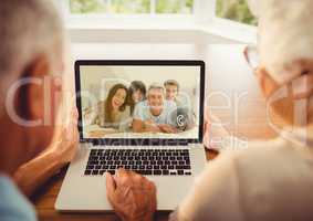 Senior couple having a video call with their family on laptop
