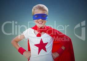 Portrait of smiling kid wearing red cape and blue mask standing with hand on hip against clear sky