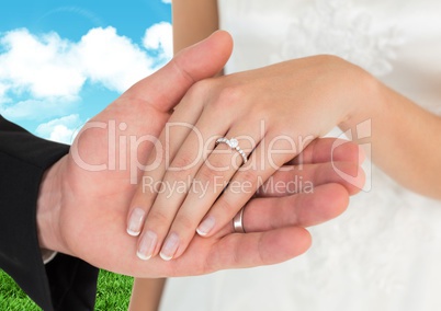 Married couple holding hands against sky in background