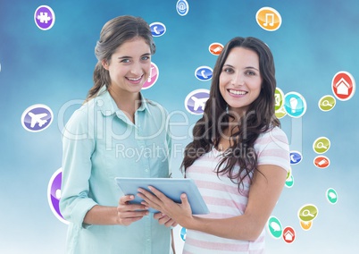 Portrait of happy women holding digital tablet with various icons in background