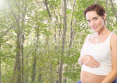 Portrait of a pregnant woman standing against greenery