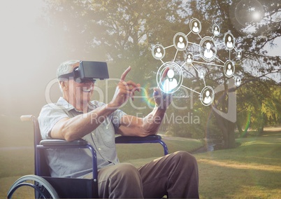 Senior man sitting on wheelchair using virtual reality headset and network connecting icons