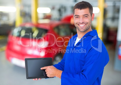 Happy automobile mechanic holding a digital tablet