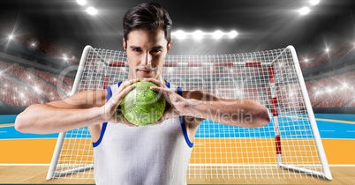 Athlete playing handball against stadium in background