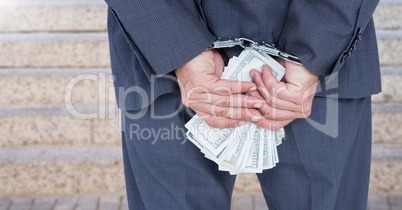 Businessman hands in handcuffs holding US dollars