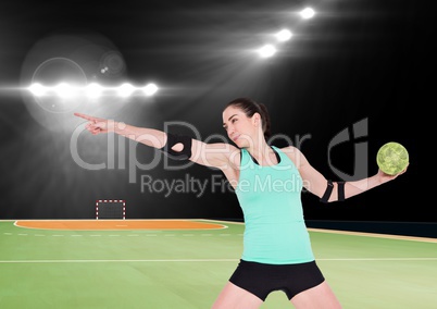 Female handball player throwing ball at handball court