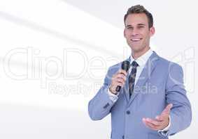 Portrait of businessman public speaking on microphone against white background
