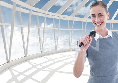Composite image of a businesswoman holding a mic