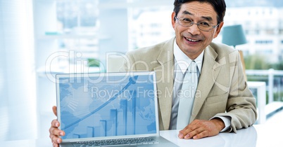 Portrait of smiling businessman showing graph on laptop