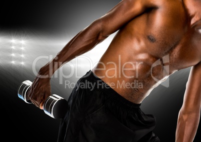 Man performing exercise with dumbbell against black background