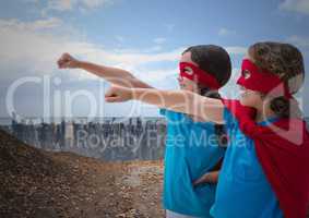 Kids in superhero costume pretending to fly against cityscape