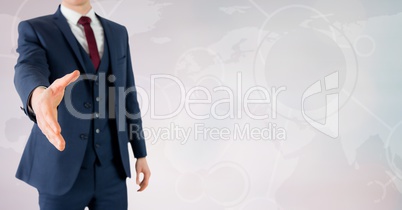 Businessman offering his hand for a handshake against world map in background