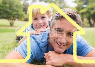 Father and son overlaid with house shape lying in park