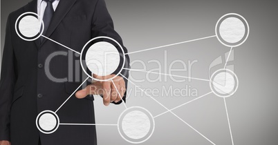 Mid-section of businessman touching digital screen against grey background