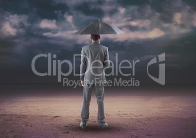 Businessman standing with umbrella against digitally generated background