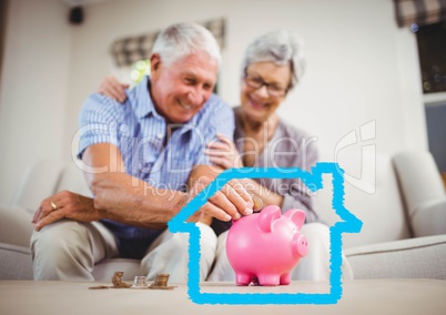 Senior couple insert coins in piggy bank against house outline