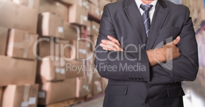 Businessman standing with his arms crossed at warehouse