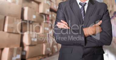 Businessman standing with his arms crossed at warehouse