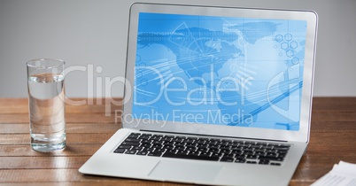 Laptop with business chart screen and glass of water